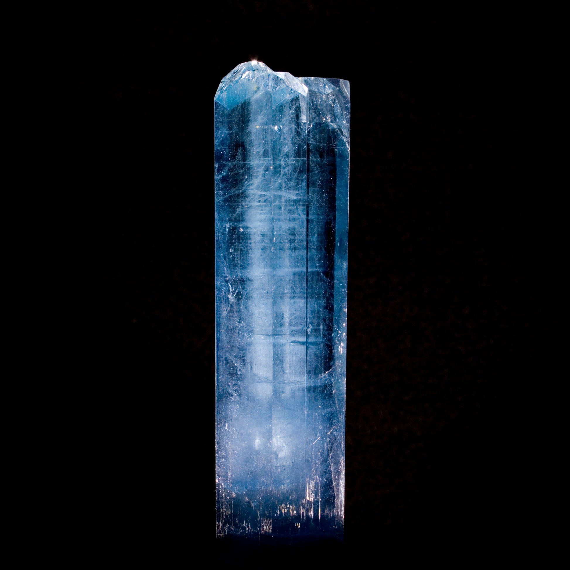 Aquamarine: Brilliant blue color with multiple terminations at the top sits in high contrast on black background. From Vietnam. All natural smooth, lustrous edges.