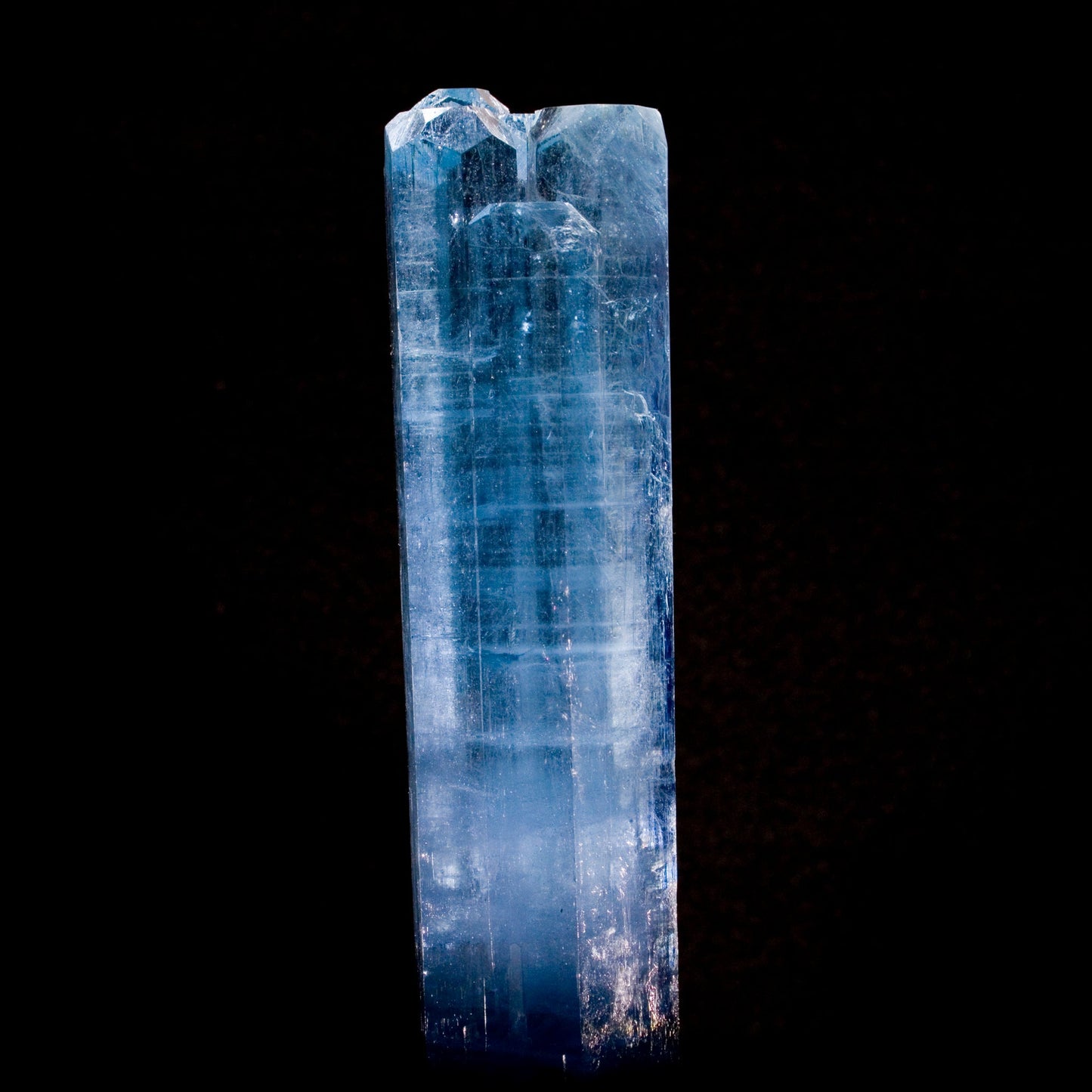 Aquamarine: Brilliant blue color with multiple terminations at the top sits in high contrast on black background. From Vietnam. All natural smooth, lustrous edges.