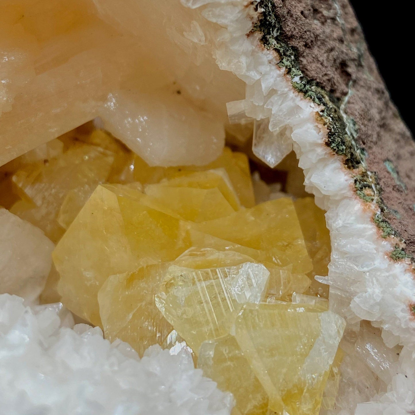 Fluorescent Powellite with Stilbite Inside Heuladnite Geode # Q8 https://www.superbminerals.us/products/fluorescent-powellite-with-stilbite-inside-heuladnite-geode-q8 Features:Beautiful vug lined with gemmy Powellite lustrous crystals inside Heulandite from Nashik, Maharashtra, India. Powellite is very rare and fluorescent collectors minerals. They have sharp pyramidal shape with glassy luster and pretty striations.Pink stilbite crystals on the edge of Heulandite. Powellite