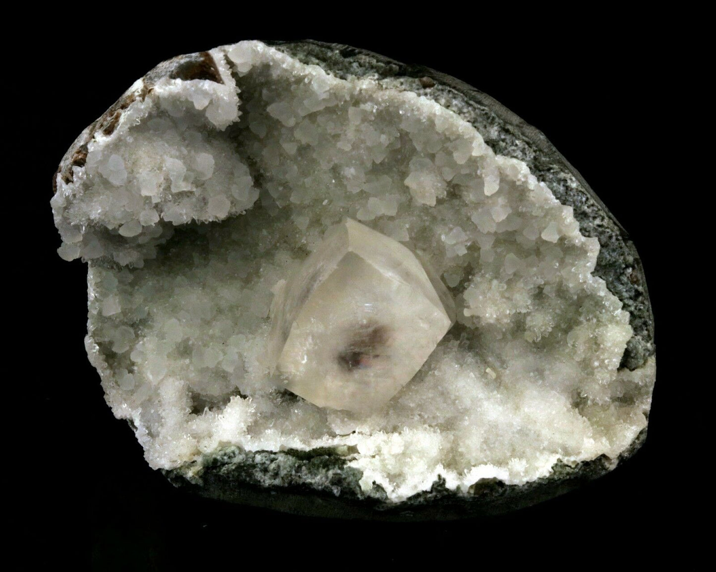 Calcite Cube inside MM Quartz Geode Natural Minerals Specimen # B 2490  https://www.superbminerals.us/products/calcite-cube-inside-mm-quartz-geode-natural-minerals-specimen-b-2490  Features: This is a superb piece that features an exceptionally large Geode lined with lustrous, colorless microcrystalline MM Quartz and MM Quartz hosting one large, translucent Calcite cube. The cube is flawless the result of being protected within a Geode and are perfectly positioned to give the piece outstanding