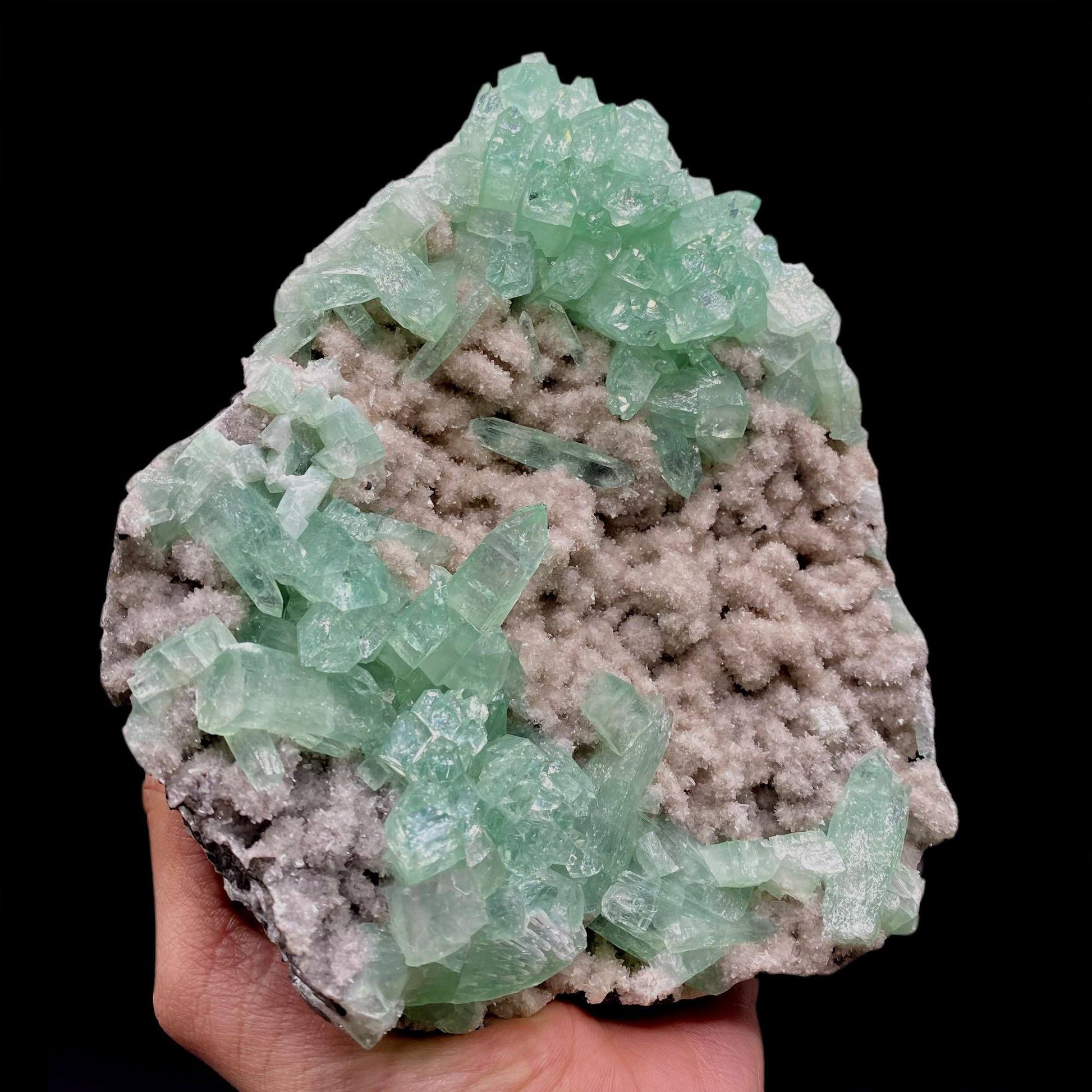 Green Apophyllite Sparkling Crystals on Heulandite Cluster # Q2  https://www.superbminerals.us/products/green-apophyllite-sparkling-crystals-on-heulandite-cluster-q2  Features:Sparkling cluster of green Apophyllite crystals in a radiating formation on matrix lined with creme-colored stilbite crystals in aggregates. The apophyllite crystals are fully terminated with vivd green color and glassy luster.&nbsp;Primary Mineral(s): ApophylliteSecondary Mineral(s): N/A Matrix: Heulandite