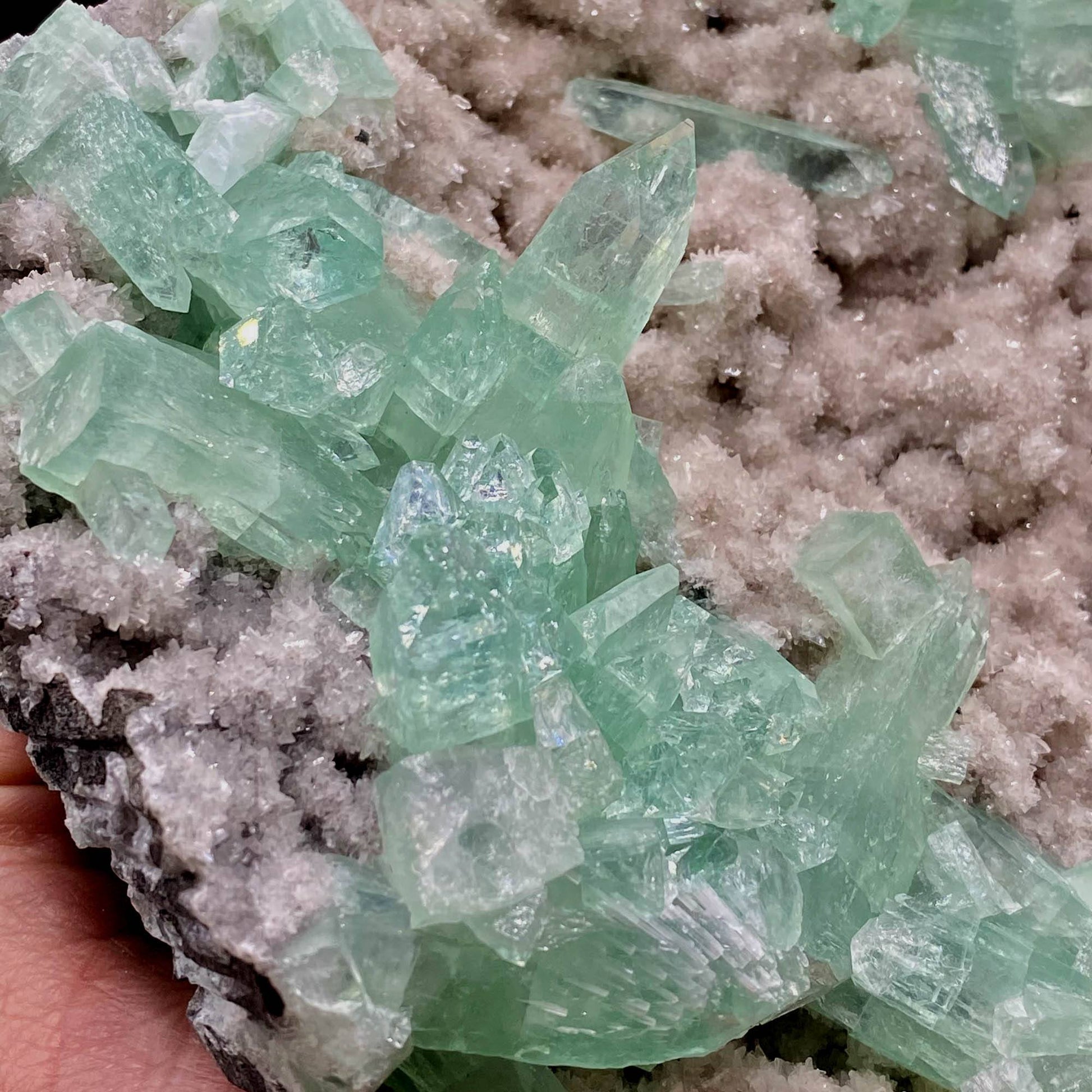 Green Apophyllite Sparkling Crystals on Heulandite Cluster # Q2  https://www.superbminerals.us/products/green-apophyllite-sparkling-crystals-on-heulandite-cluster-q2  Features:Sparkling cluster of green Apophyllite crystals in a radiating formation on matrix lined with creme-colored stilbite crystals in aggregates. The apophyllite crystals are fully terminated with vivd green color and glassy luster.&nbsp;Primary Mineral(s): ApophylliteSecondary Mineral(s): N/A Matrix: Heulandite