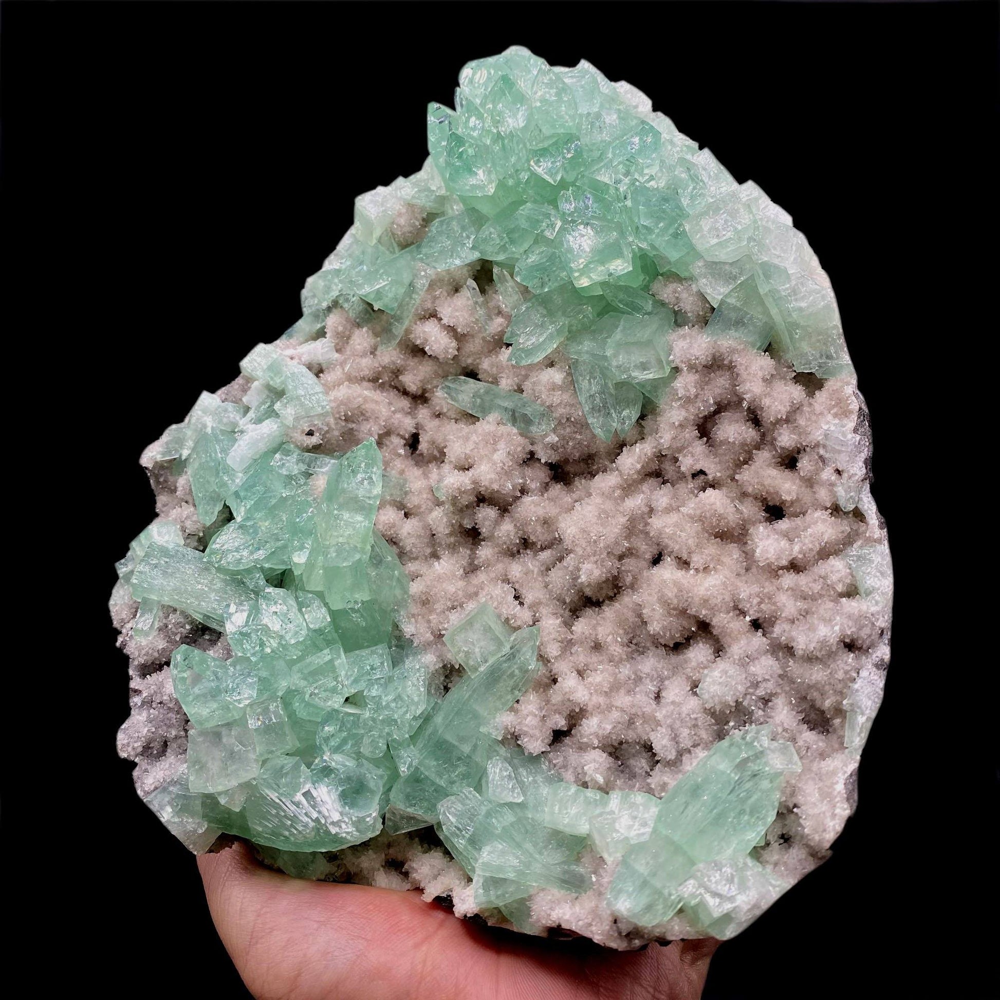 Green Apophyllite Sparkling Crystals on Heulandite Cluster # Q2  https://www.superbminerals.us/products/green-apophyllite-sparkling-crystals-on-heulandite-cluster-q2  Features:Sparkling cluster of green Apophyllite crystals in a radiating formation on matrix lined with creme-colored stilbite crystals in aggregates. The apophyllite crystals are fully terminated with vivd green color and glassy luster.&nbsp;Primary Mineral(s): ApophylliteSecondary Mineral(s): N/A Matrix: Heulandite