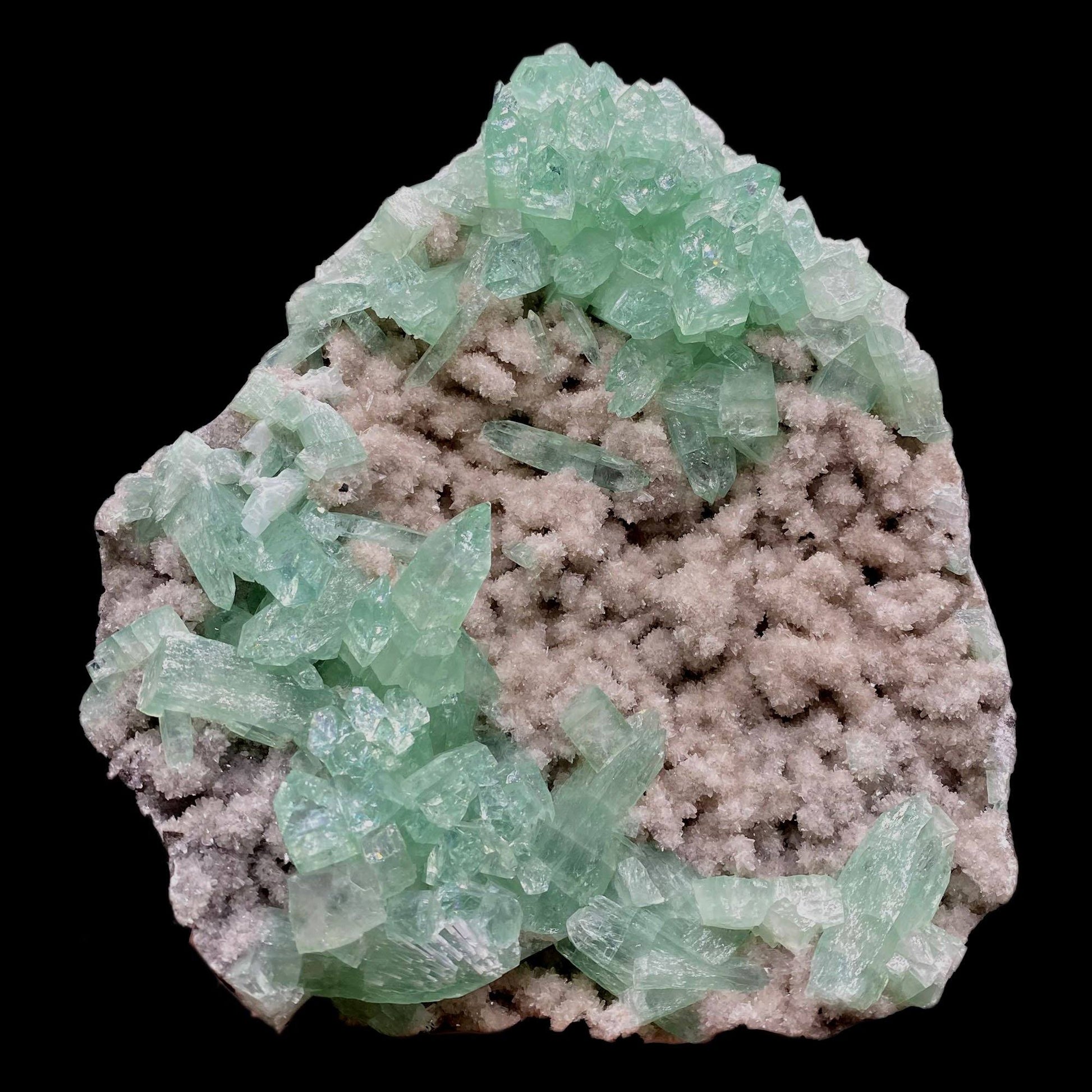 Green Apophyllite Sparkling Crystals on Heulandite Cluster # Q2  https://www.superbminerals.us/products/green-apophyllite-sparkling-crystals-on-heulandite-cluster-q2  Features:Sparkling cluster of green Apophyllite crystals in a radiating formation on matrix lined with creme-colored stilbite crystals in aggregates. The apophyllite crystals are fully terminated with vivd green color and glassy luster.&nbsp;Primary Mineral(s): ApophylliteSecondary Mineral(s): N/A Matrix: Heulandite